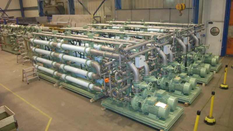 A large Hamworthy MBR system destined for a cruise ship, seen during factory inspection, showing the finished membrane skids in the foreground with the inter-stage filtration units behind
