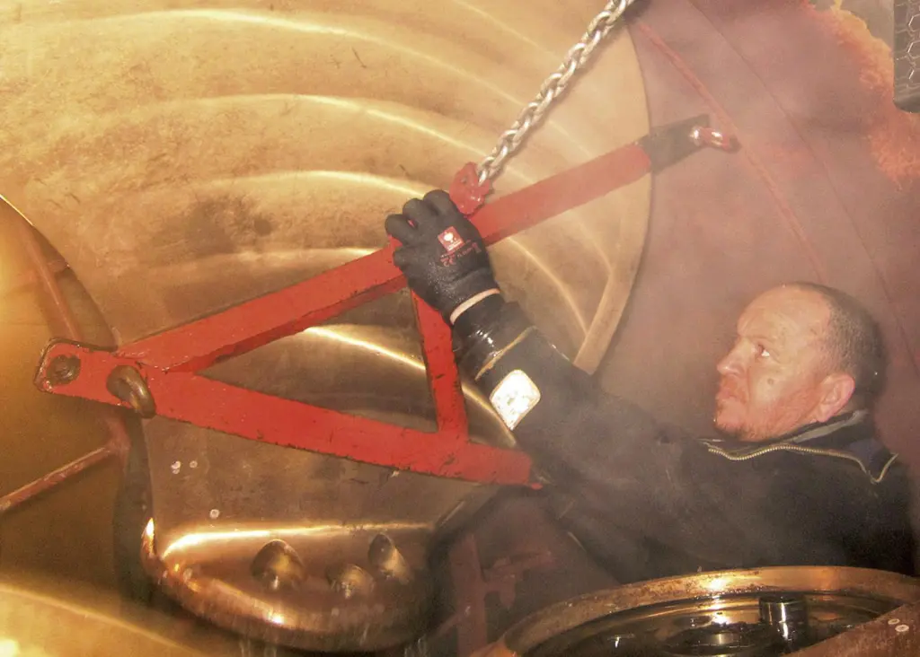 Lifting one of the old thruster blades inside the closed-off thruster tunnel