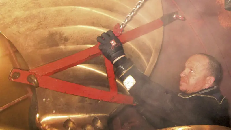 Lifting one of the old thruster blades inside the closed-off thruster tunnel