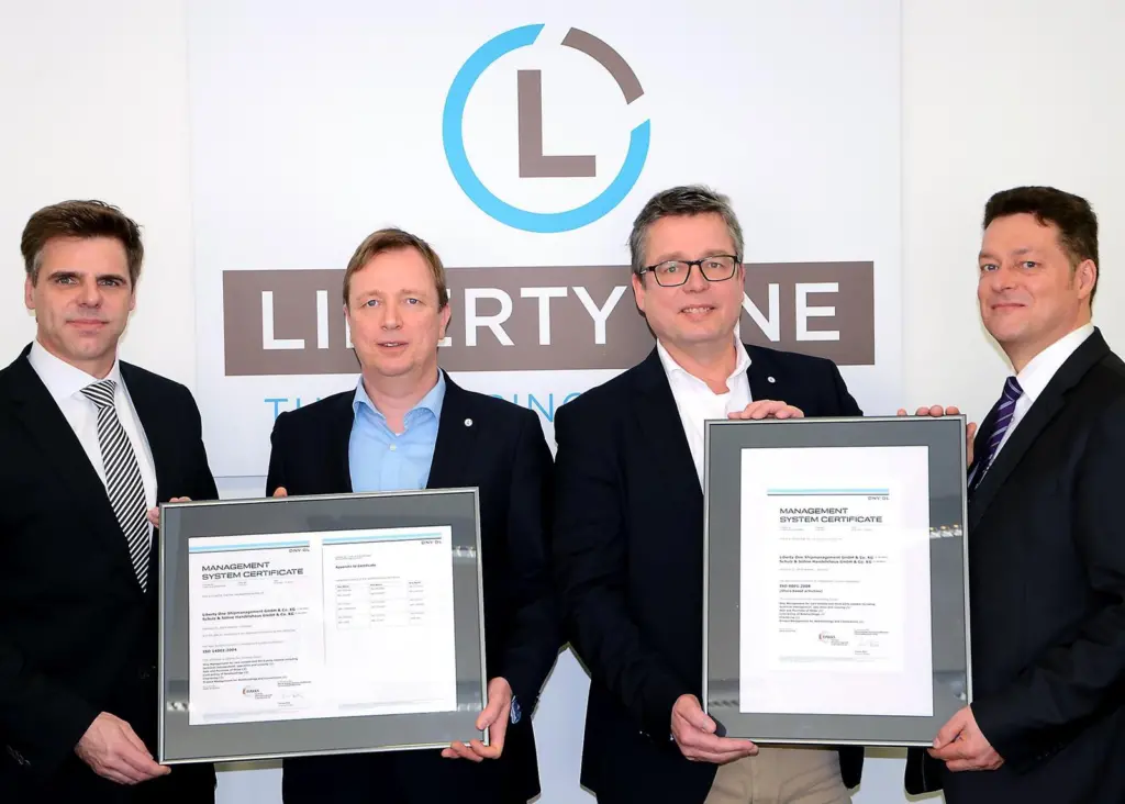 DNV GL’s Matthias Ritters, regional manager Germany (left) and Frank Hensel, key account manager at the classification society (right) hand over the ISO certificates to Liberty One’s managing director Dietrich Schulz (second from right) and Capt...