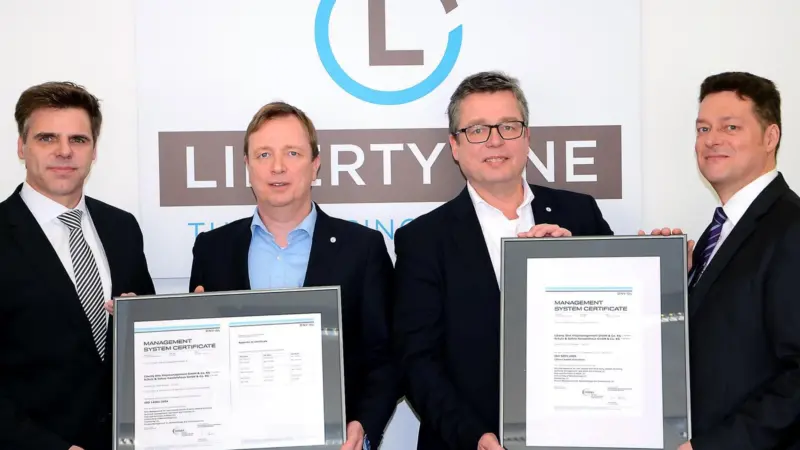 DNV GL’s Matthias Ritters, regional manager Germany (left) and Frank Hensel, key account manager at the classification society (right) hand over the ISO certificates to Liberty One’s managing director Dietrich Schulz (second from right) and Capt...