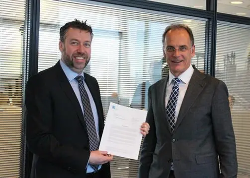 Morten Jensen, sales & marketing manager at Lloyd's Register (left) handing over the statement of fact to Ulrich Schittek, head of management services, after sales, at Maersk Tankers (right) Photo: Maersk Tankers