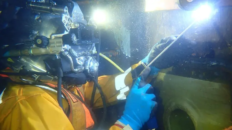 Wärtsilä Underwater Services’ diver performing a scrubber overboard repair on a container vessel.
