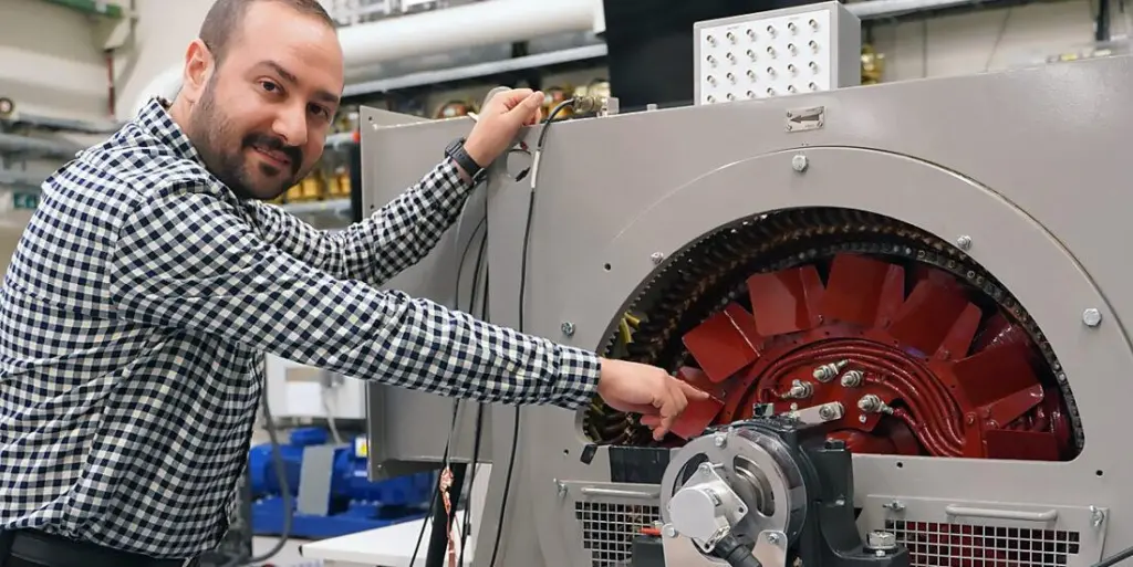 Hossein Ehya, a researcher at Norway's NTNU, alongside a purpose built generator model in NTNU’s SmartGrid laboratory.