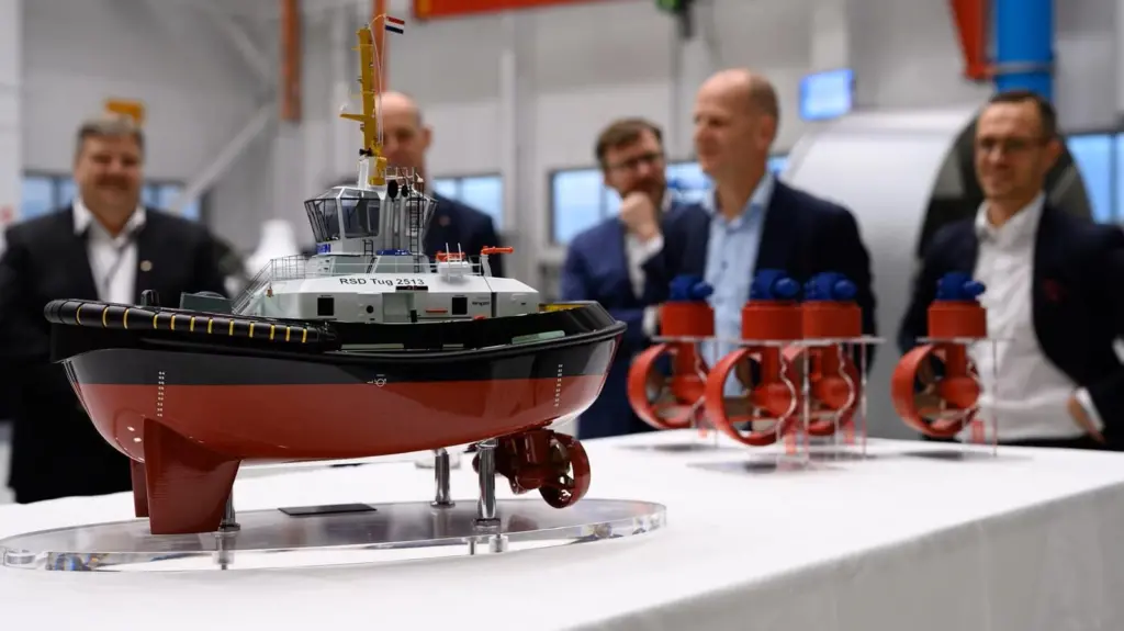 Miniature model of a Damen RSD Tug 2513 with five men in the background
