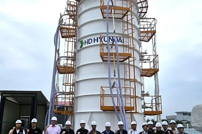 Workers in white hard hats in front of an HD KSOE LH2 vacuum tank