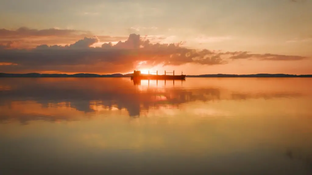 A ship silhouetted against a salmon pink sunset