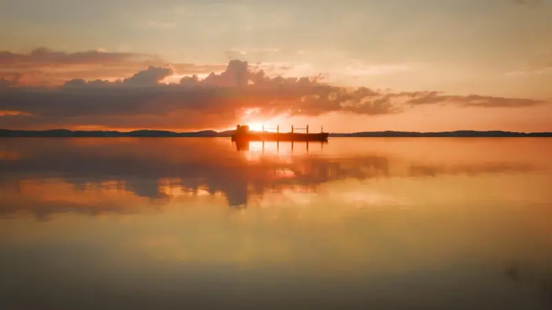 A ship silhouetted against a salmon pink sunset