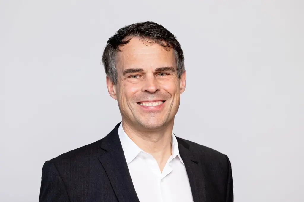 The image shows a headshot of Daniel Bischofberger, CEO of Accelleron smiling at the camera