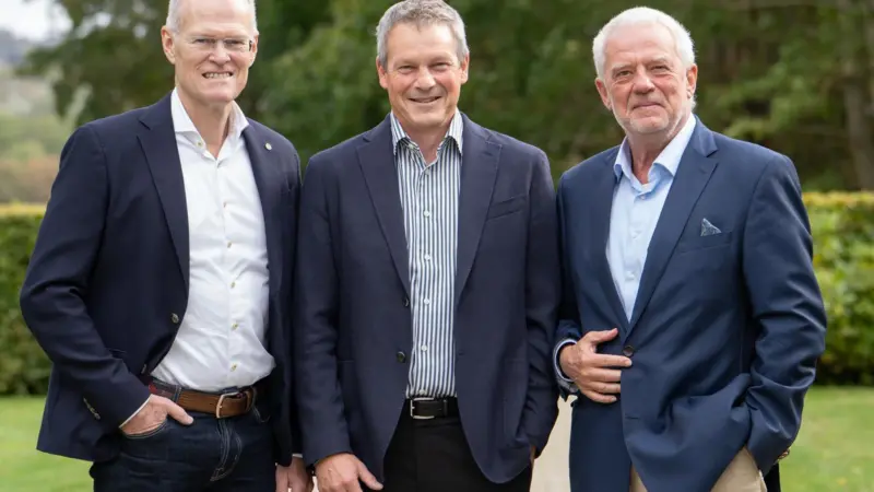 The image shows Kim Bengtsen, Henrik Sørensen and Søren Ø. Sørensen smiling at the camera