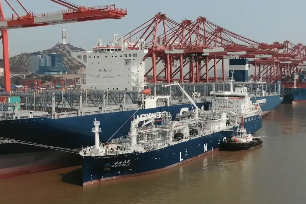 SIPG's LNG bunkering vessel alongside a containership with cranes dockside