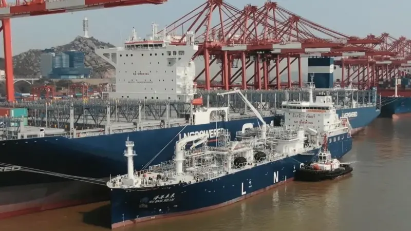 SIPG's LNG bunkering vessel alongside a containership with cranes dockside
