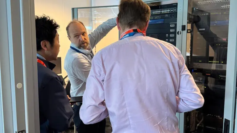 Three men looking at some equipment